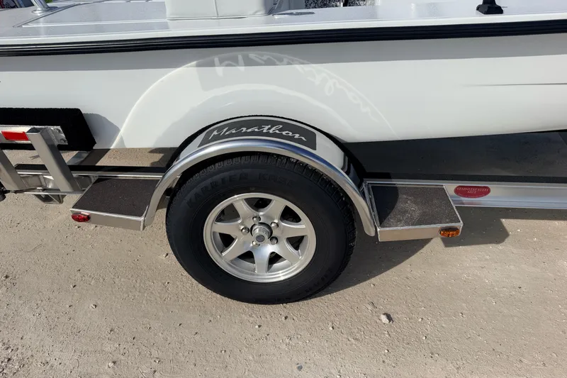 Slide: The Image of 2021 Hell's Bay Marathon boat trailer with silver wheel on sandy ground. - 31