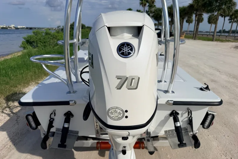 Slide: The Image of 2021 Hell's Bay Marathon boat with Yamaha 70 outboard motor, near a scenic waterfront. - 24