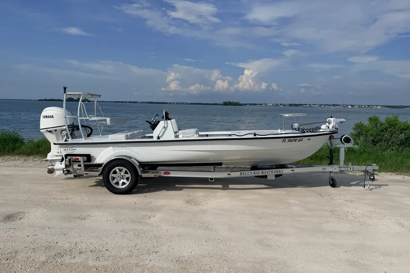Slide: The Image of 2021 Hell's Bay Marathon boat on trailer by waterfront, clear sky background. - 1