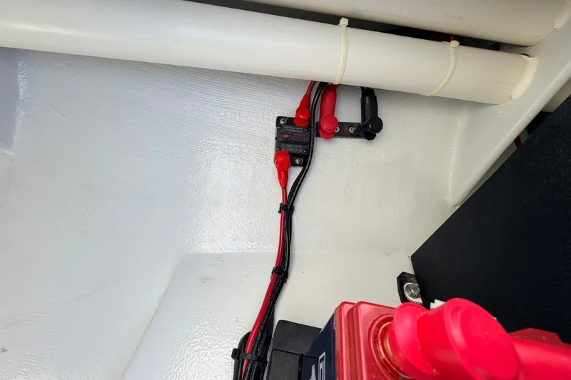 Slide: The Image of 2021 Hell's Bay Marathon boat wiring setup with red and black cables. - 46