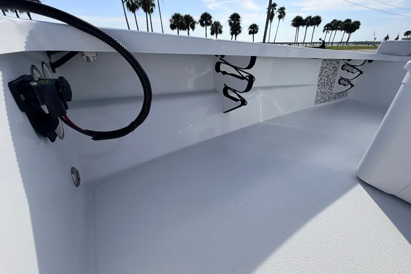 Slide: The Image of 2021 Hell's Bay Marathon boat interior with rod holders and wiring, under a clear sky. - 51