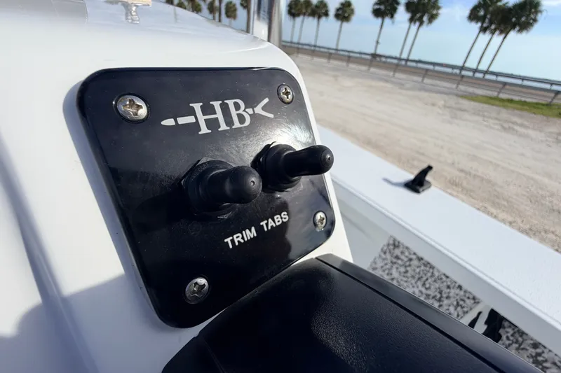 Slide: The Image of Hell's Bay Marathon 2021 boat trim tabs control panel with palm trees in background. - 58