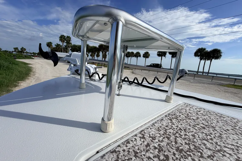 Slide: The Image of 2021 Hell's Bay Marathon boat deck with railing, near palm trees and coastal road. - 34