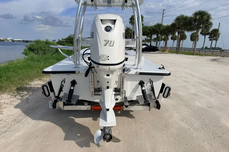 Slide: The Image of 2021 Hell's Bay Marathon boat with Yamaha 70 engine, parked near a scenic waterfront. - 2