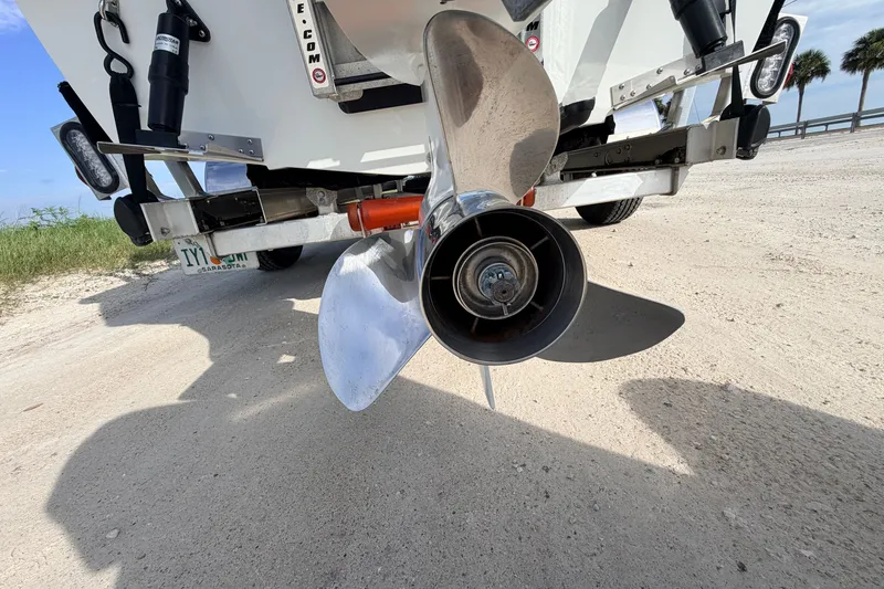 Slide: The Image of 2021 Hell's Bay Marathon boat propeller on sandy shore, clear sky background. - 29