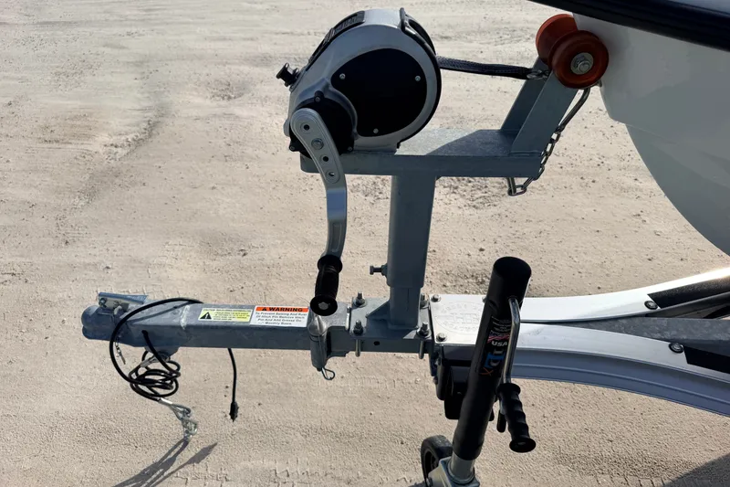 Slide: The Image of Trailer hitch and winch of a 2021 Hell's Bay Marathon boat on sandy ground. - 17