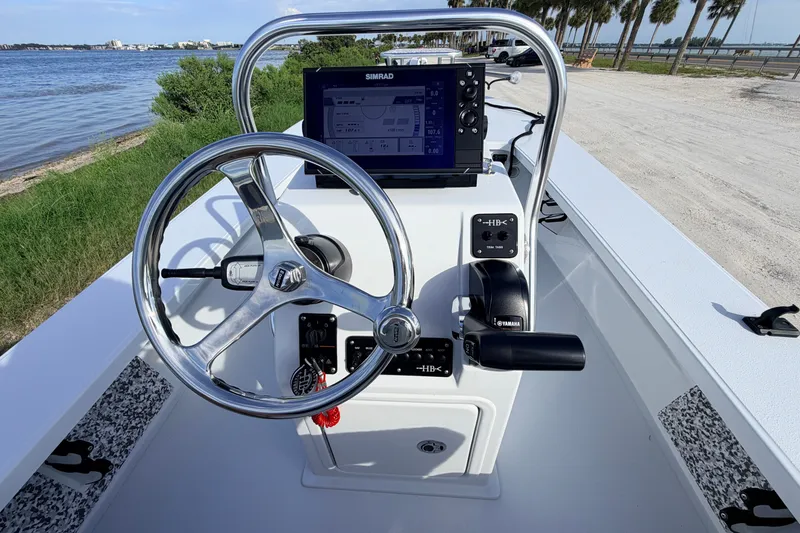 Slide: The Image of 2021 Hell's Bay Marathon boat console with steering wheel and navigation system by the water. - 55