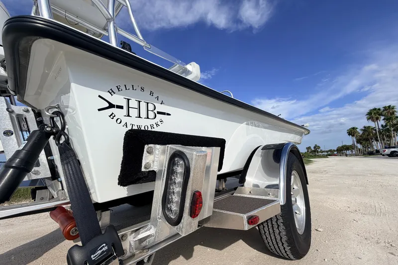 Slide: The Image of 2021 Hell's Bay Marathon boat on trailer, clear sky, palm trees in background. - 30