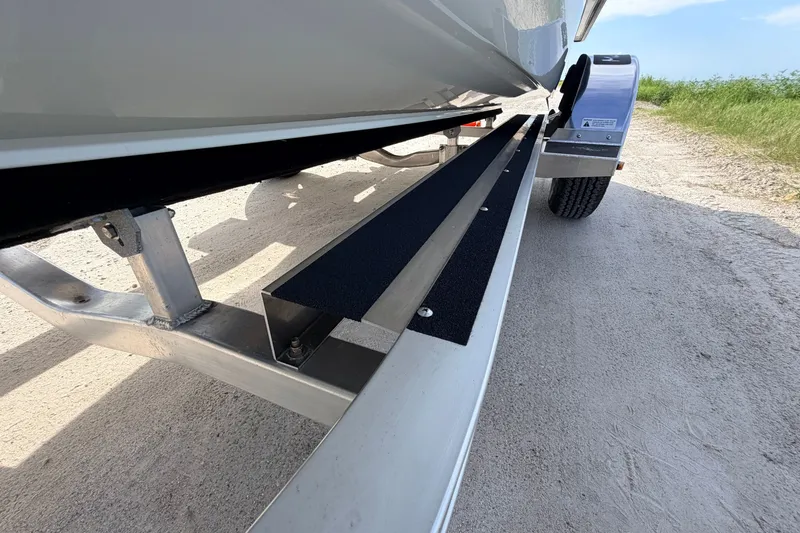 Slide: The Image of 2021 Hell's Bay Marathon boat trailer on sandy terrain, showcasing sturdy construction. - 16