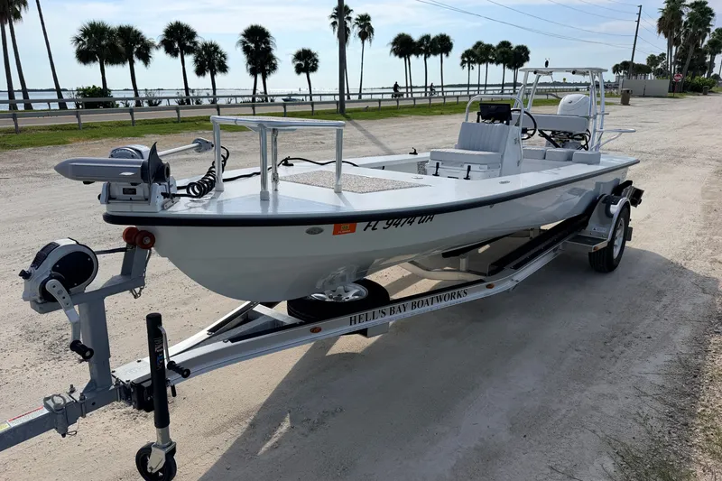 Slide: The Image of 2021 Hell's Bay Marathon boat on trailer, parked near palm trees and waterfront. - 5