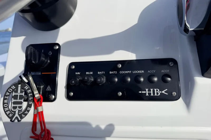 Slide: The Image of Control panel of a 2021 Hell's Bay Marathon boat with switches and key. - 59