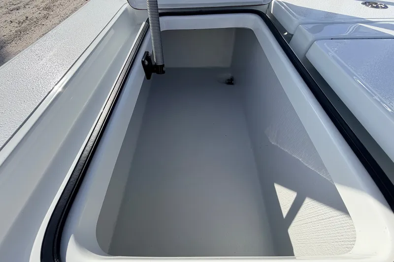 Slide: The Image of 2021 Hell's Bay Marathon boat storage compartment, open and empty, with a sleek white interior. - 69
