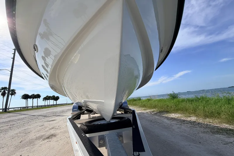 Slide: The Image of 2021 Hell's Bay Marathon boat on trailer by scenic waterfront road. - 8