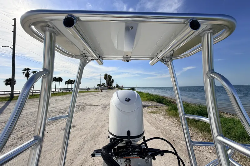 Slide: The Image of 2021 Hell's Bay Marathon boat with T-top, parked by a scenic coastal road. - 79
