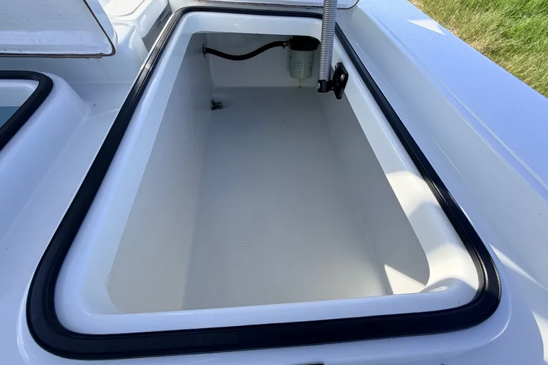 Slide: The Image of 2021 Hell's Bay Marathon boat storage compartment, open and empty, with visible drainage system. - 73