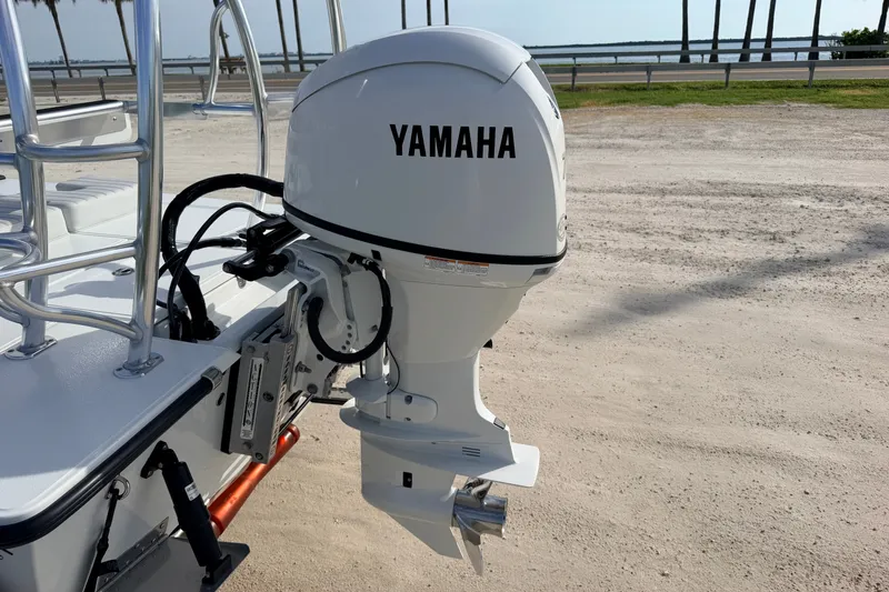 Slide: The Image of 2021 Hell's Bay Marathon boat with Yamaha outboard motor, parked near a scenic waterfront. - 26