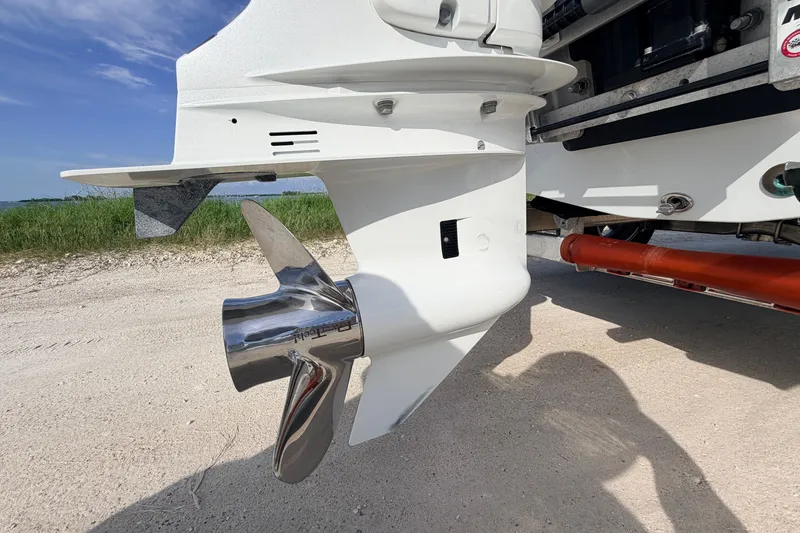 Slide: The Image of 2021 Hell's Bay Marathon boat propeller on sandy shore, showcasing sleek design. - 22