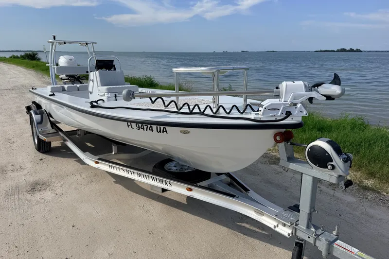 Slide: The Image of 2021 Hell's Bay Marathon boat on trailer by waterfront, featuring sleek design and modern equipment. - 6