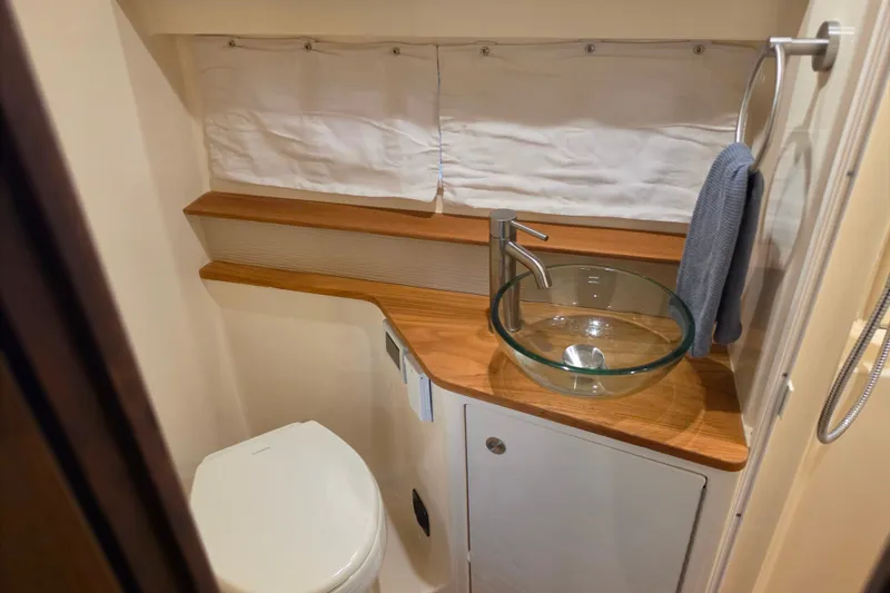 Slide: The Image of 2021 Sea Ray Sundancer 350 bathroom with glass sink and wooden countertop. - 50