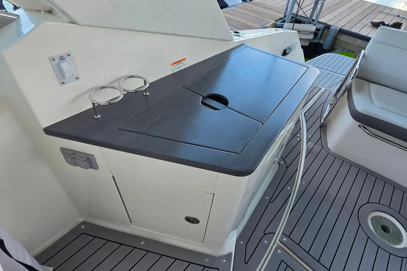 Slide: The Image of 2021 Sea Ray Sundancer 350 cockpit with sleek countertop and integrated cup holders. - 21