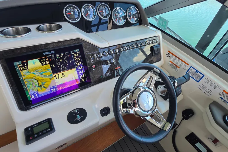 Slide: The Image of 2021 Sea Ray Sundancer 350 helm with Simrad display and chrome steering wheel. - 31