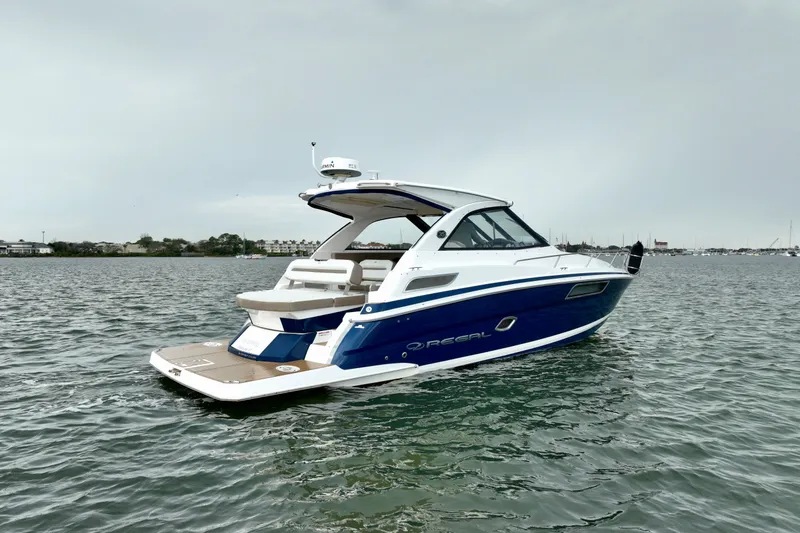 The Image of 2017 Regal 35 Sport Coupe boat on calm water, showcasing sleek design and luxury features. - 3