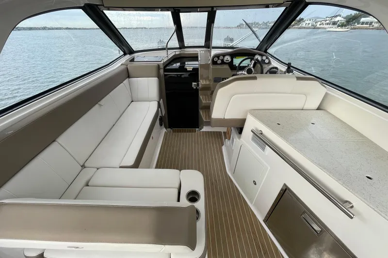 Slide: The Image of Interior of 2017 Regal 35 Sport Coupe, featuring elegant seating and helm, overlooking water. - 17