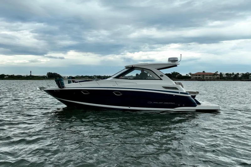 Slide: The Image of 2017 Regal 35 Sport Coupe boat on calm water under cloudy sky. - 9