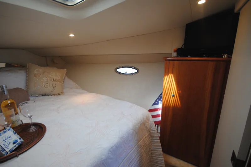 Slide: The Image of Cozy cabin interior of 2000 Silverton 351 Sedan with bed, TV, and American flag. - 22