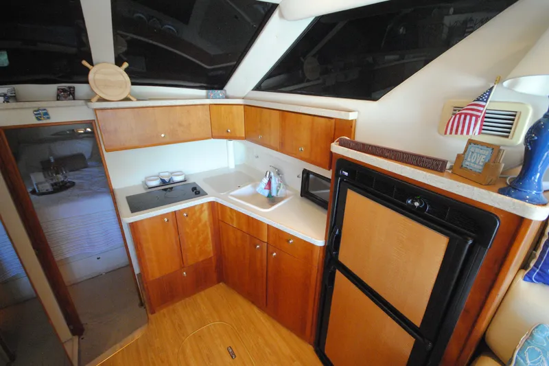 Slide: The Image of Interior of 2000 Silverton 351 Sedan yacht kitchen with wood cabinetry and appliances. - 18