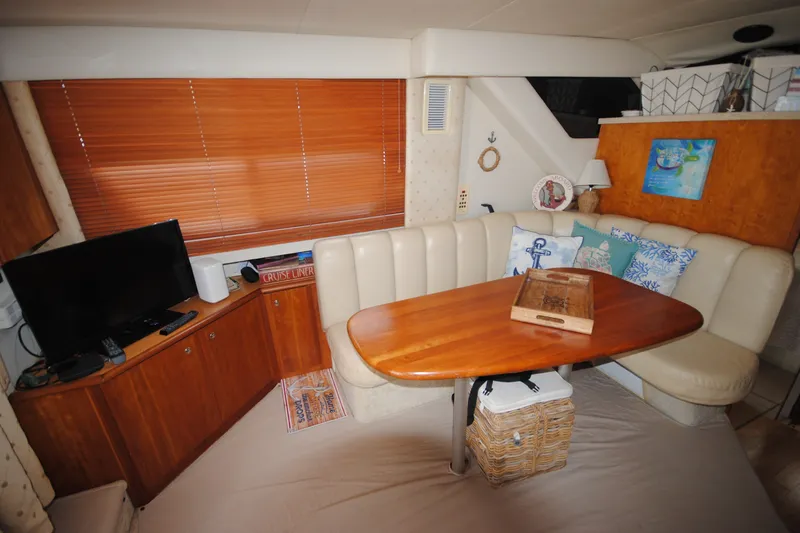 Slide: The Image of Interior of 2000 Silverton 351 Sedan with cozy seating, wooden table, and TV. - 16