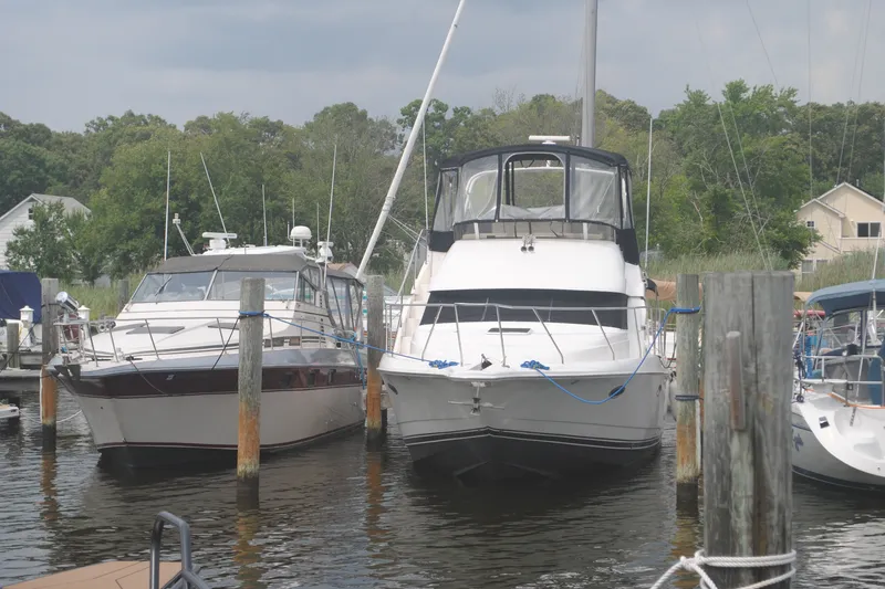 Slide: The Image of 2000 Silverton 351 Sedan yacht docked at a marina with surrounding boats. - 5