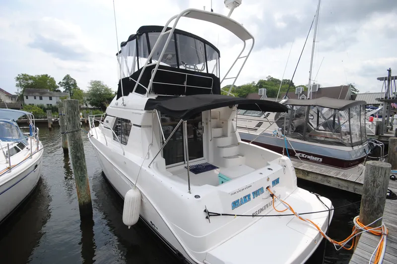Slide: The Image of 2000 Silverton 351 Sedan yacht docked at marina, featuring spacious deck and flybridge. - 1