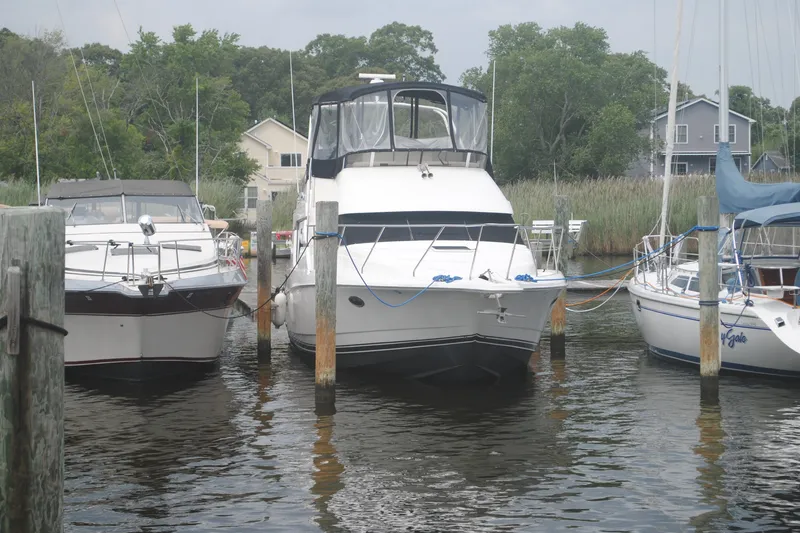 Slide: The Image of 2000 Silverton 351 Sedan yacht docked between two boats in a marina. - 4