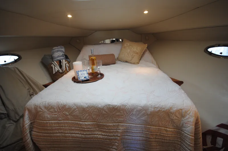 Slide: The Image of Cozy cabin interior of 2000 Silverton 351 Sedan with a neatly arranged bed and soft lighting. - 20