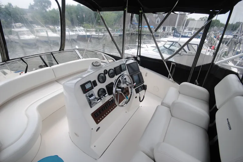 Slide: The Image of Interior view of a 2000 Silverton 351 Sedan yacht cockpit with white seating and control panel. - 10