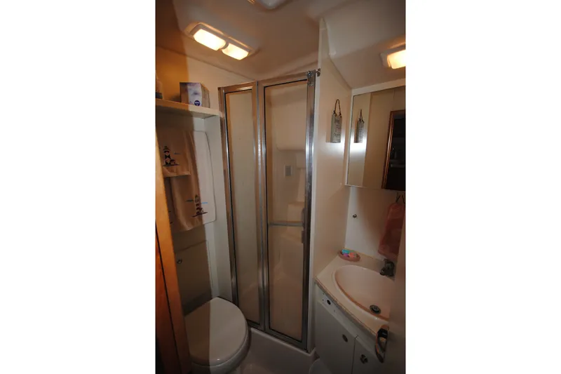 Slide: The Image of Compact bathroom in a 2000 Silverton 351 Sedan yacht with shower and sink. - 24
