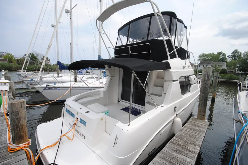 The Image of 2000 Silverton 351 Sedan yacht docked at marina, featuring sleek design and spacious deck. - 0