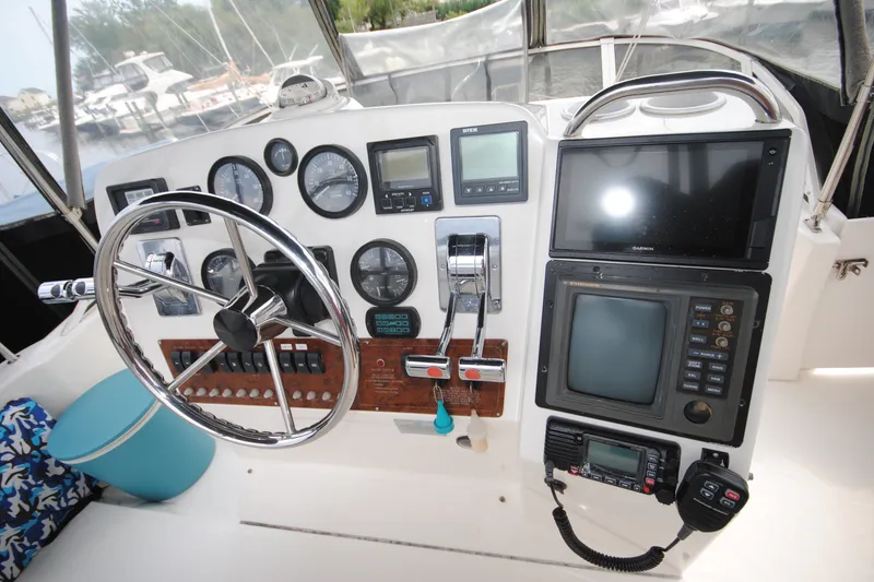 Slide: The Image of Control panel of a 2000 Silverton 351 Sedan boat with steering wheel and navigation instruments. - 12