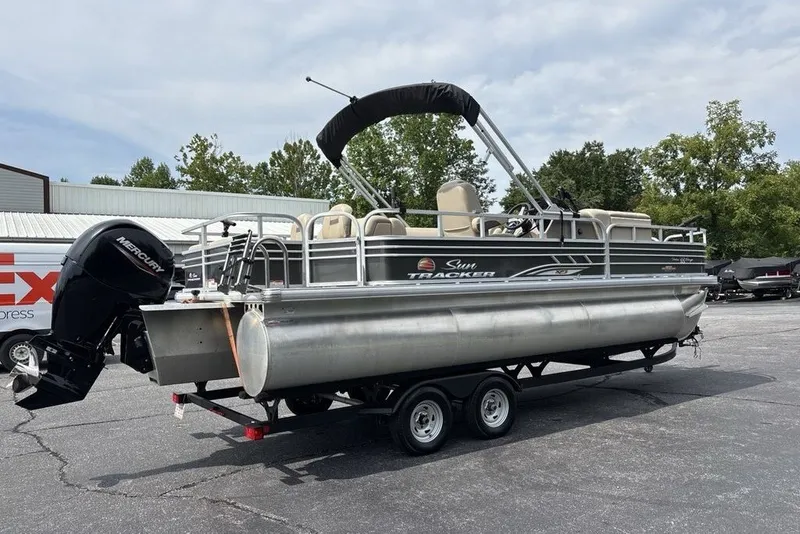 Slide: The Image of 2027 Sun Tracker Fishin' Barge 22 XP3 pontoon boat on trailer, parked outdoors. - 26