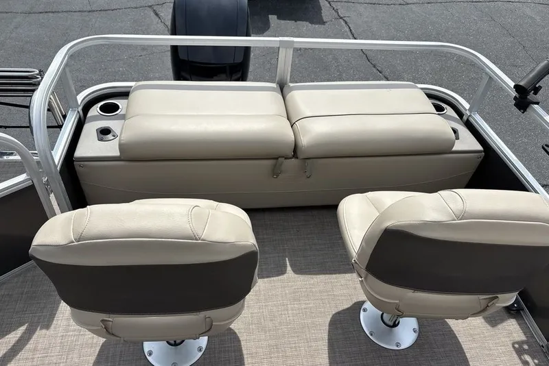 Slide: The Image of 2027 Sun Tracker Fishin' Barge 22 XP3 interior with beige seating and cup holders. - 15