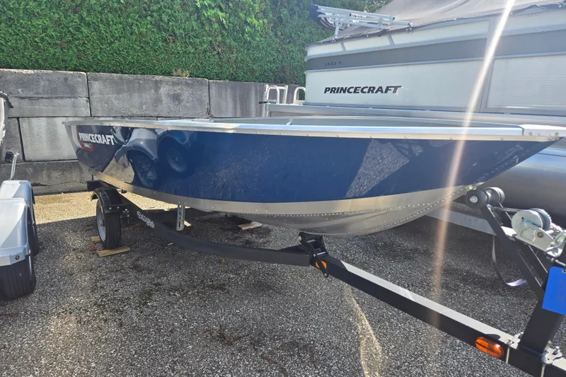 The Image of A blue 2026 Princecraft Yukon 14 L WT on a trailer, surrounded by other boats. - 0