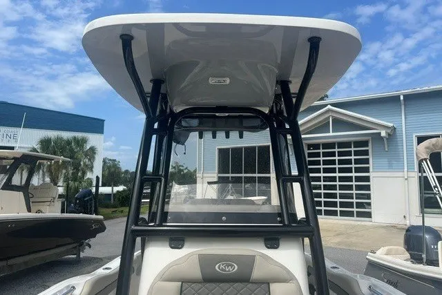 Slide: The Image of 2026 Key West 219 FS boat with T-top, parked outdoors near a blue building. - 6