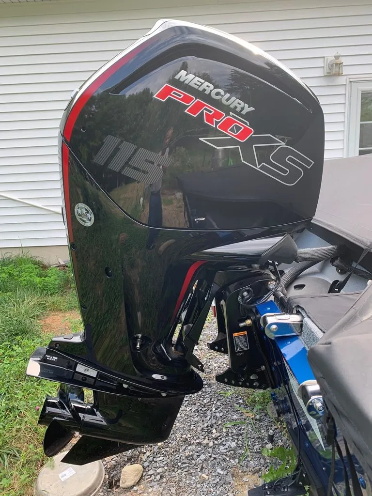 Slide: The Image of A Mercury Pro XS outboard motor is mounted on a boat parked on a gravel path. - 10
