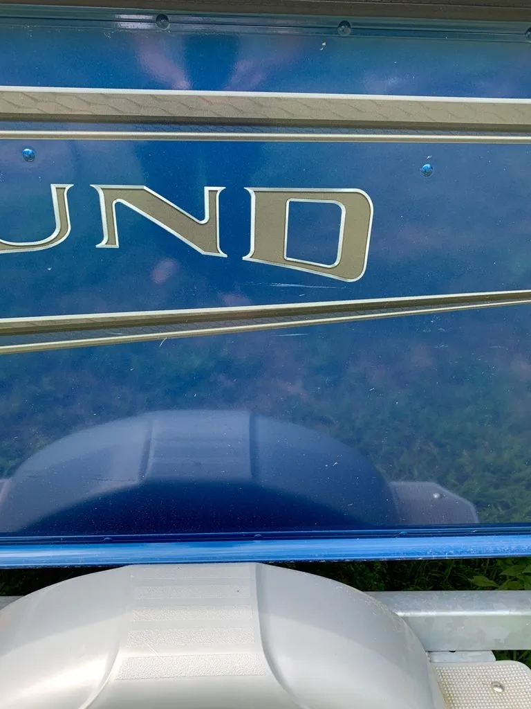 Slide: The Image of Close-up of a blue Lund boat hull with gold lettering. - 22