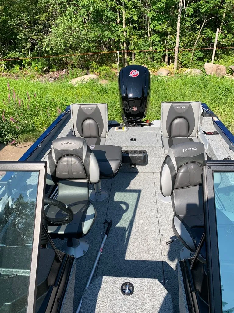 Slide: The Image of The image shows a 2024 Lund 1775 Adventure Sport boat with gray seats and an outboard motor. - 2