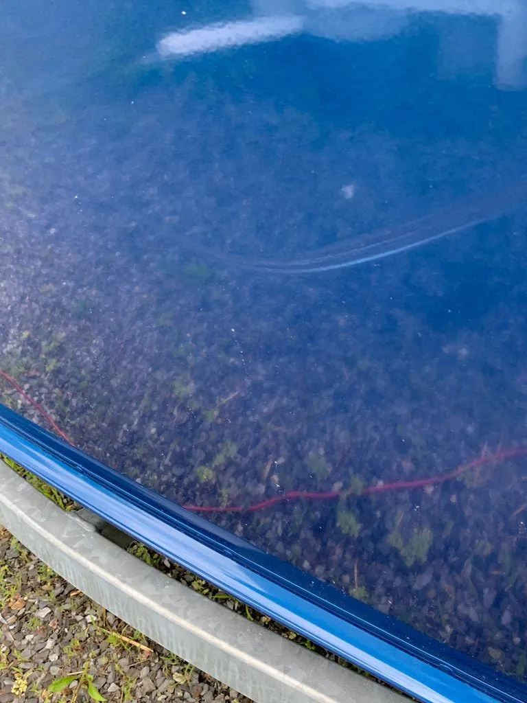 Slide: The Image of Close-up of a blue boat hull on a gravel surface. - 21