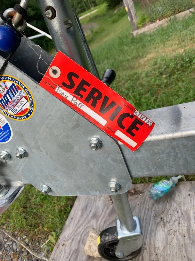 Slide: The Image of A boat trailer with a red "Service" sticker and a blue sticker beside it. - 23