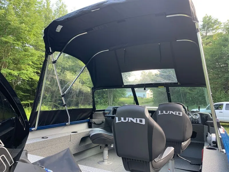 Slide: The Image of The image shows the interior of a 2024 Lund 1775 Adventure Sport boat with two seats and a canopy. - 1