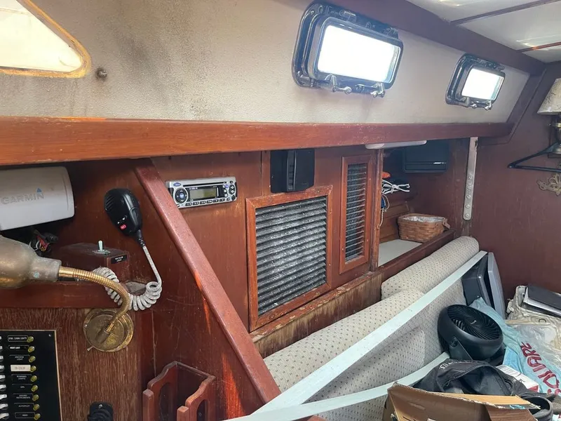 Slide: The Image of The interior of a 1985 Catalina Morgan 43 features wood paneling, a radio, and a microphone. - 5